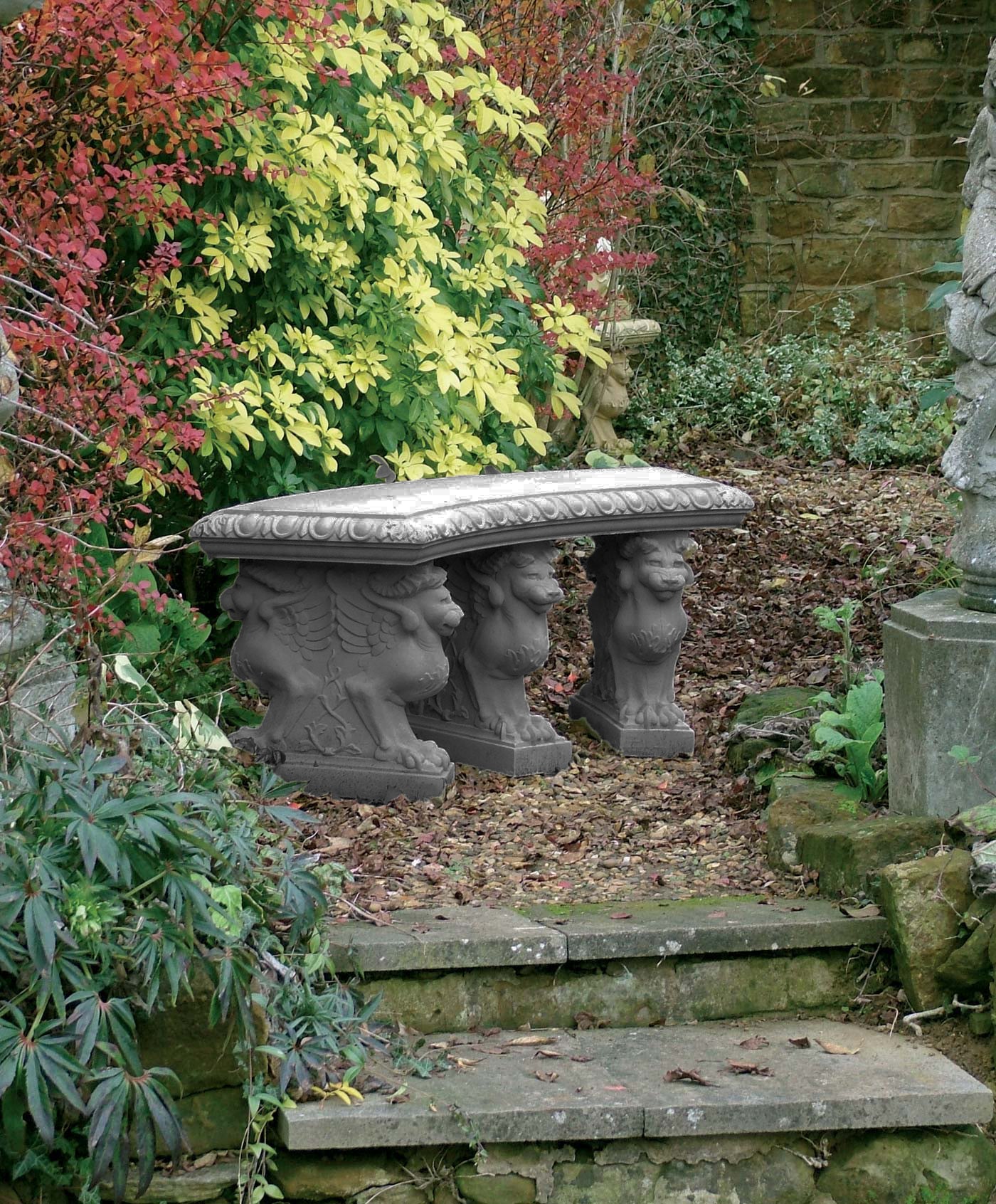Stenbänk med böjd sits och mytologiska figurer.